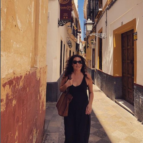 Viil walking in the sun in an old street in Seville. 